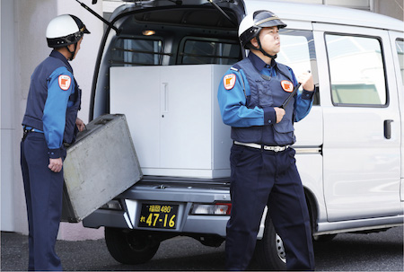 車に荷物を積み込んでいる警備員